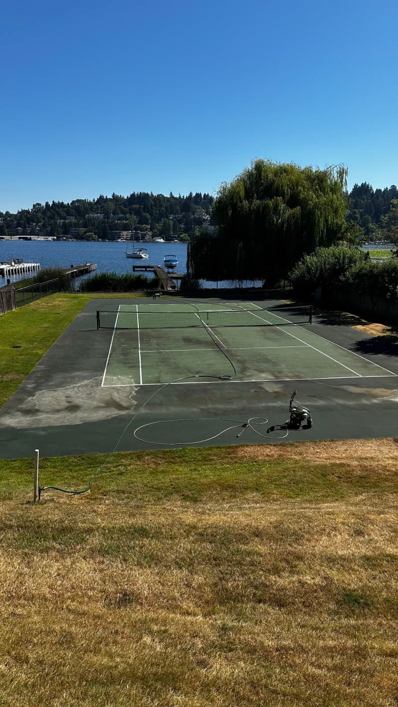 Before photo showing cracked and faded tennis court surface needing resurfacing
