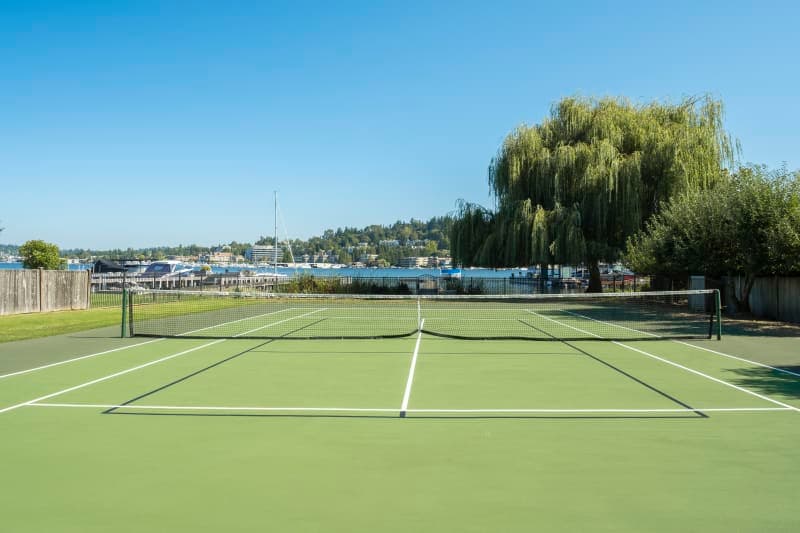 Ground-level view of professional court resurfacing with vibrant acrylic colors and clean line striping