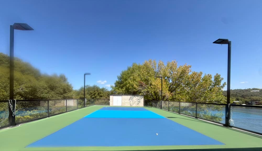 Navy, light blue and green color coats down on the rooftop pickleball court before striping on Lake Austin, Texas