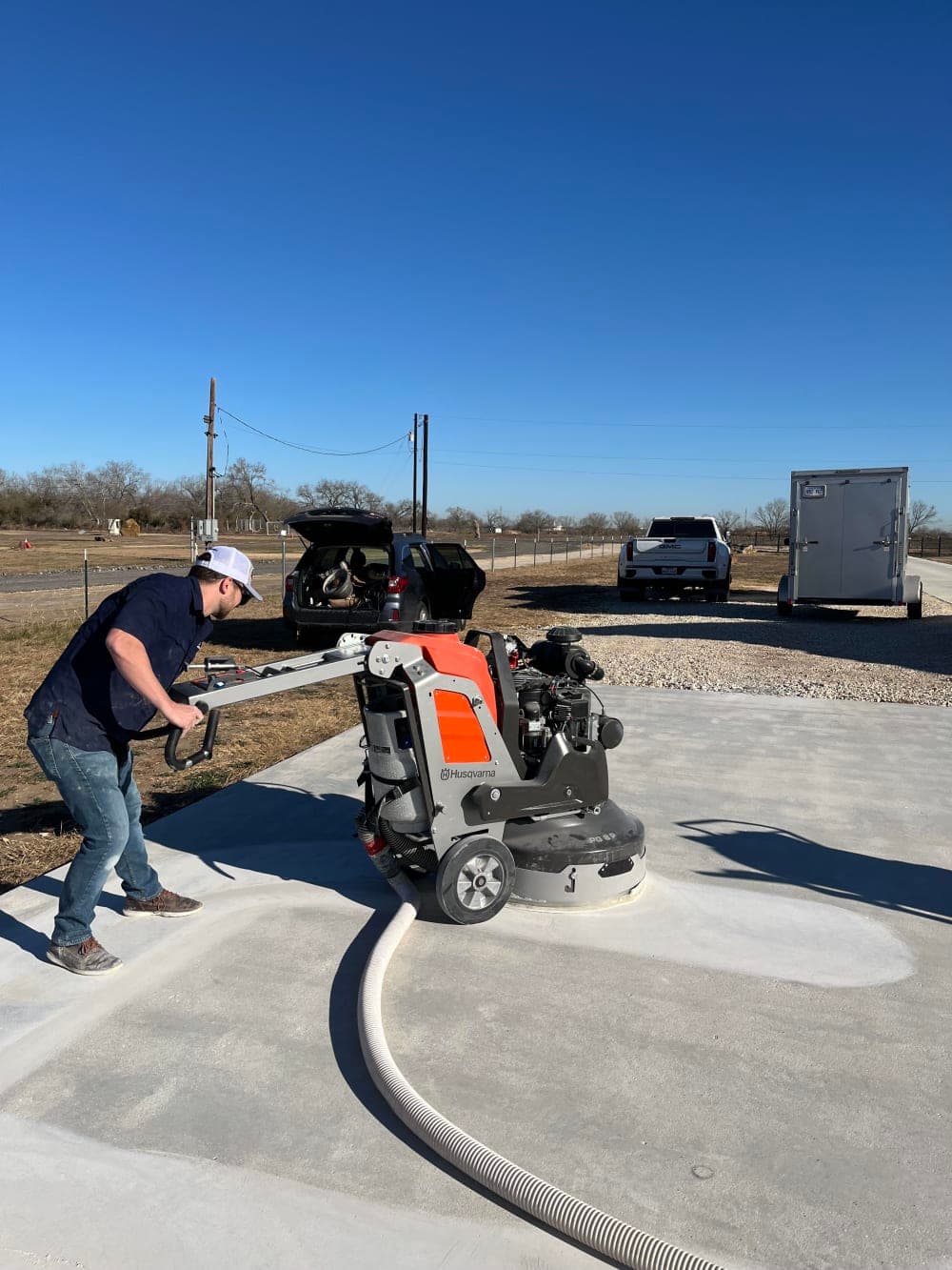 Crew grinding and prepping the concrete slab before pickleball court surfacing near San Antonio, Texas