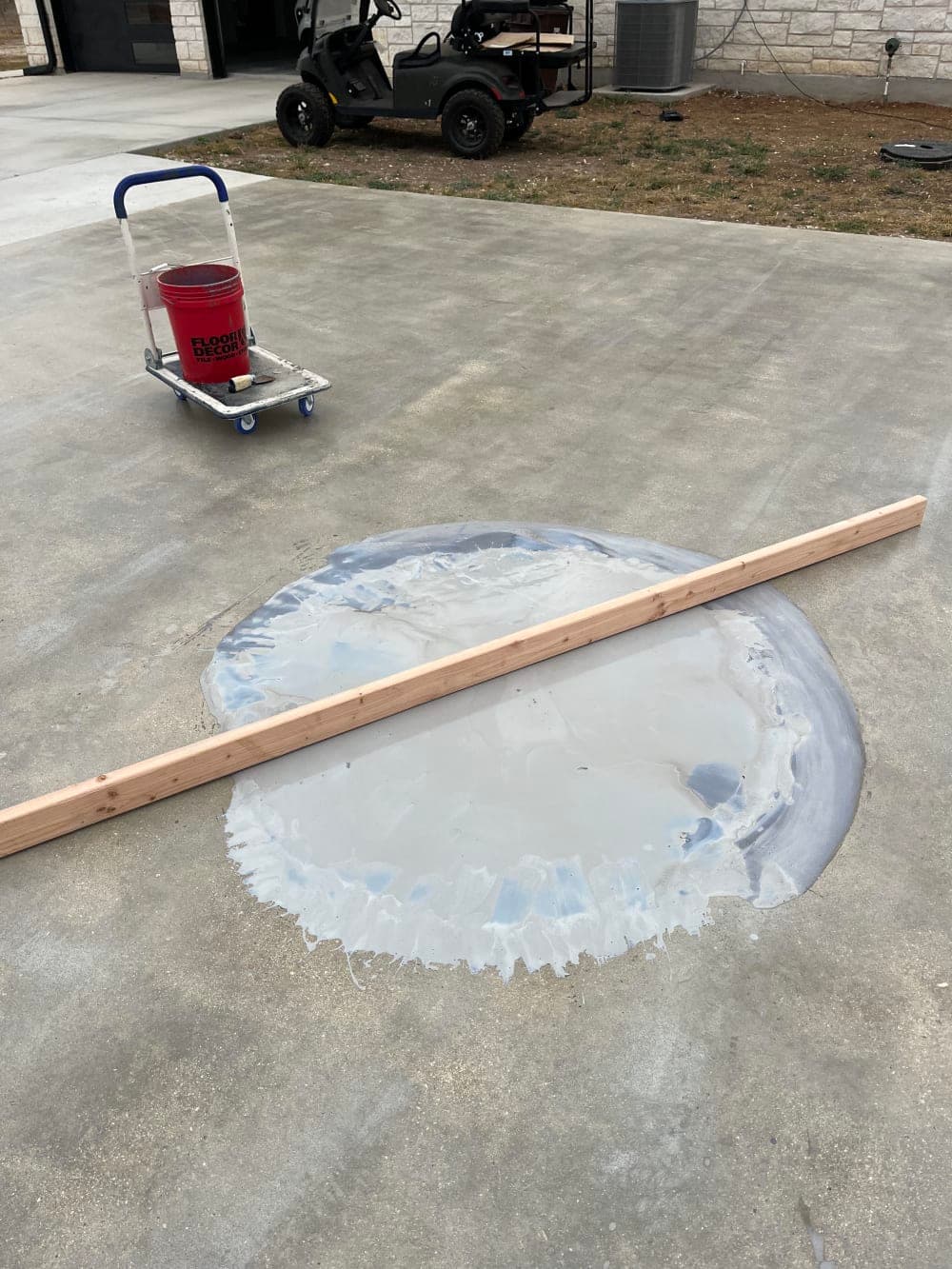 Leveling a low spot in the concrete slab with patching compound and a screed board near San Antonio, Texas