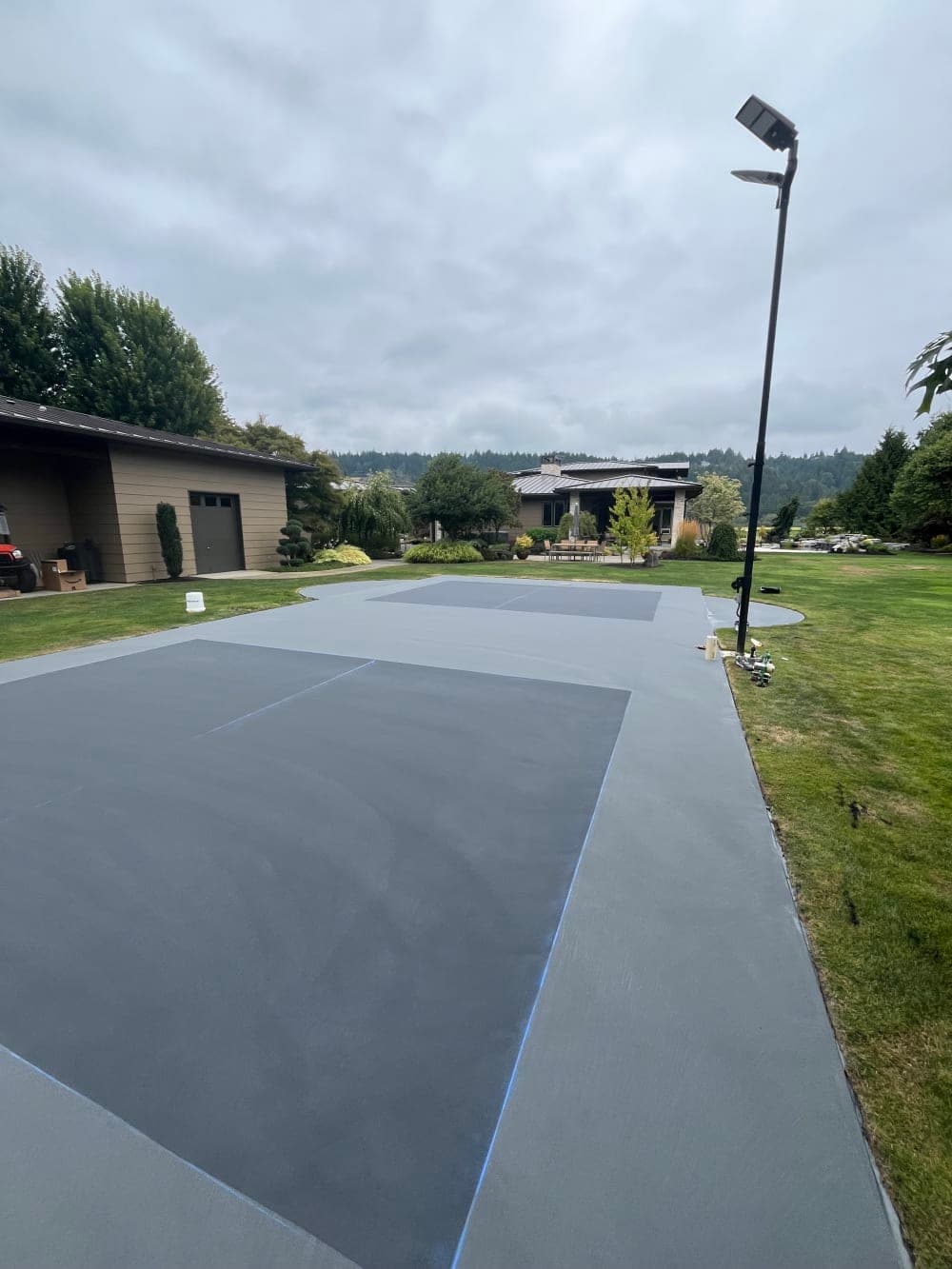 Slate playing boxes applied inside the gray surround on the pickleball court in Sumner, Washington