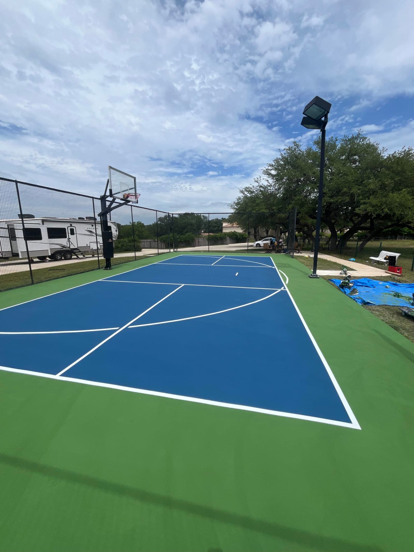 Finished blue and green multi-sport basketball court with fresh white striping in Wimberley, Texas
